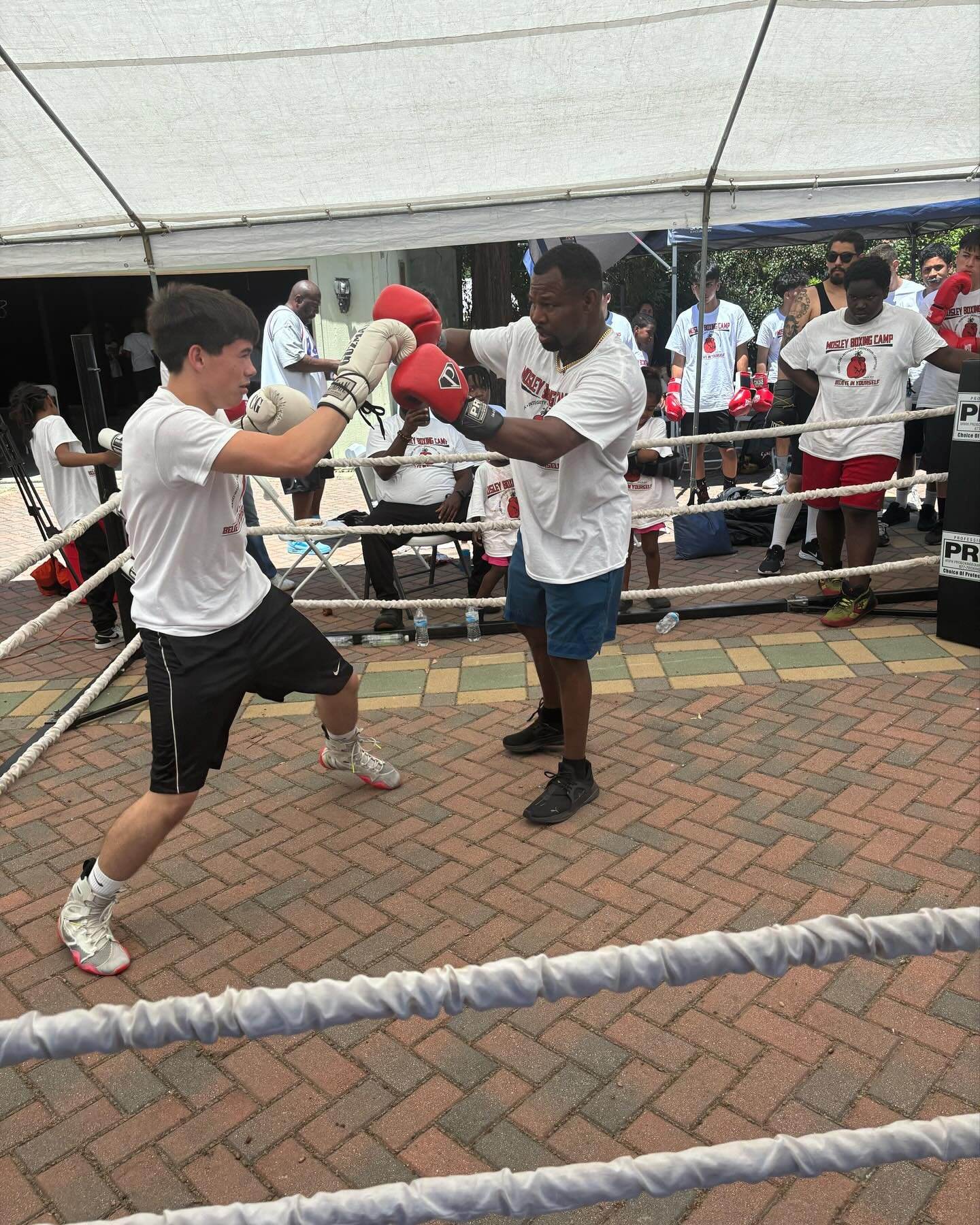 Shane Mosley working pads with a young boxer at the Mosley Boxing Camp