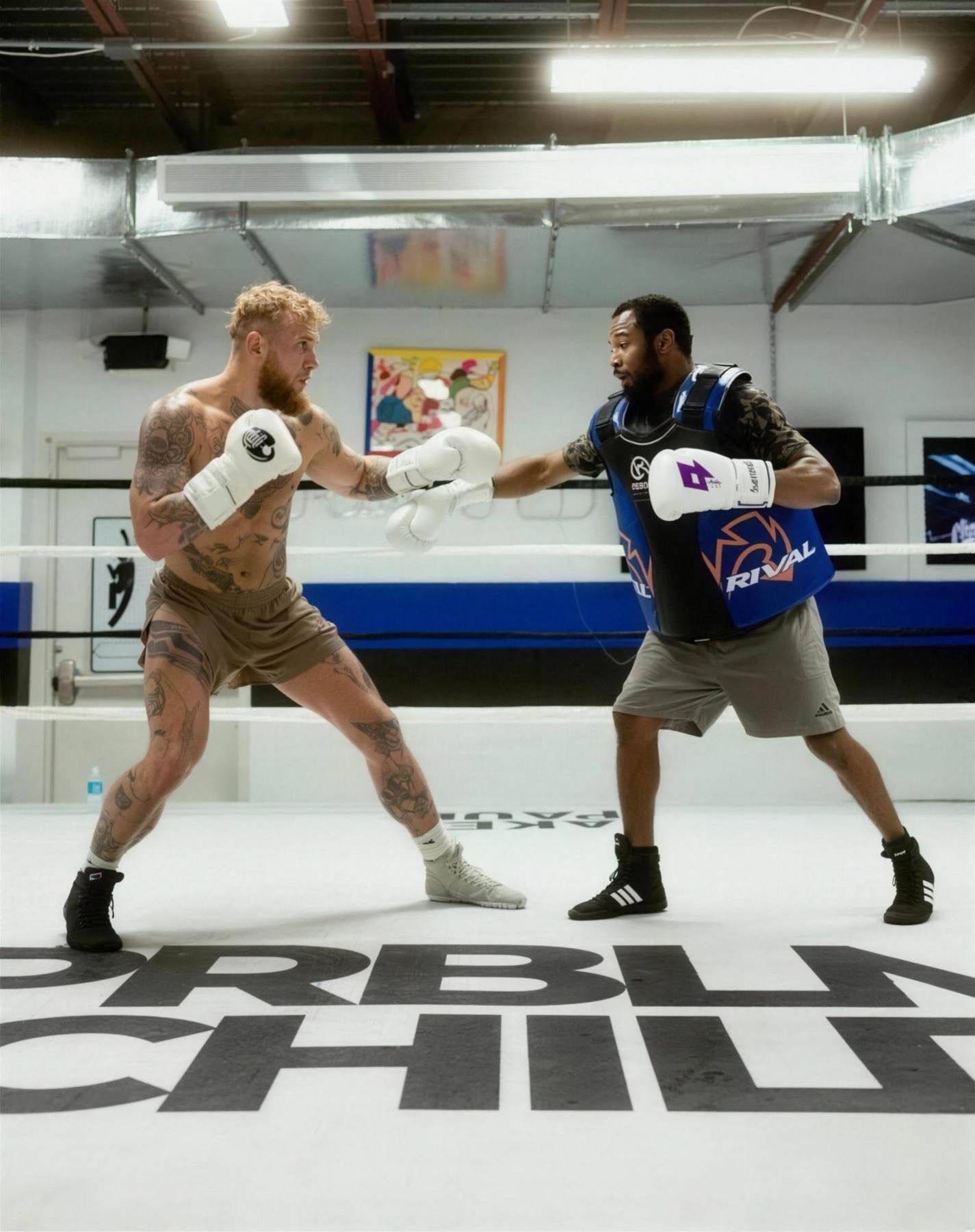 Shane Mosley working pads with Jake Paul in the gym